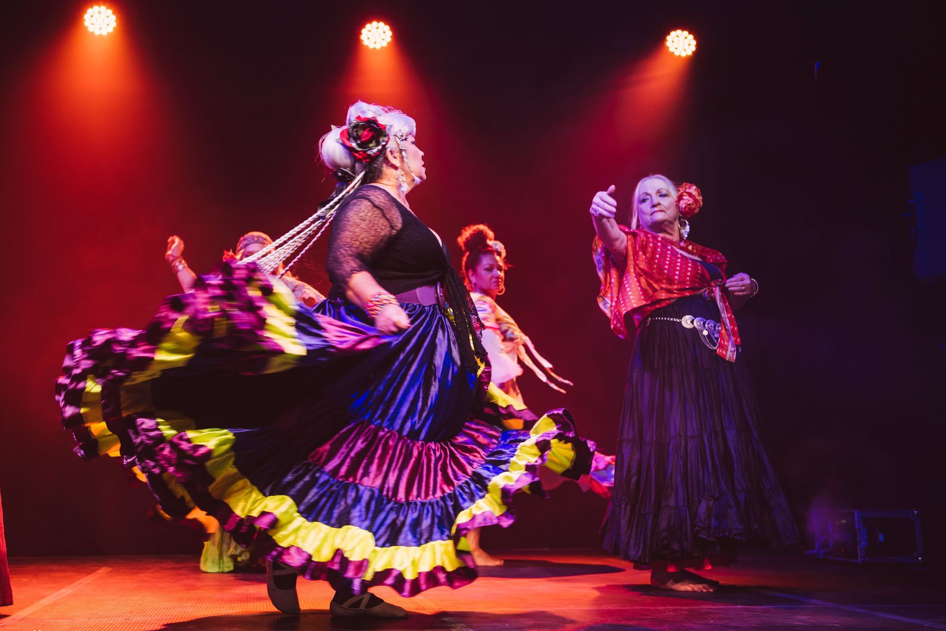 A group of women in colourful skirts are dancing on a stage — Global Dance Collective In West End, QLD
