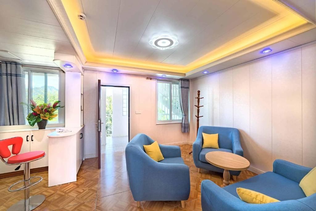 Living room with blue furniture, small round table, and a small counter with a red stool.