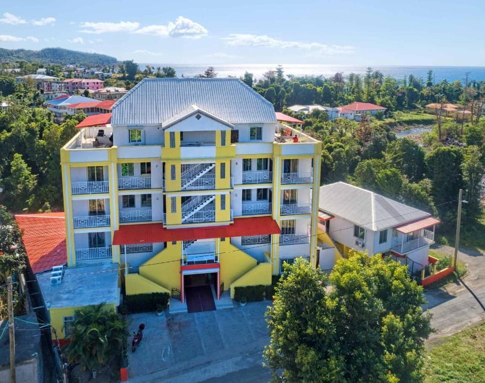 Yellow and red multi-story building with balconies near the coast.
