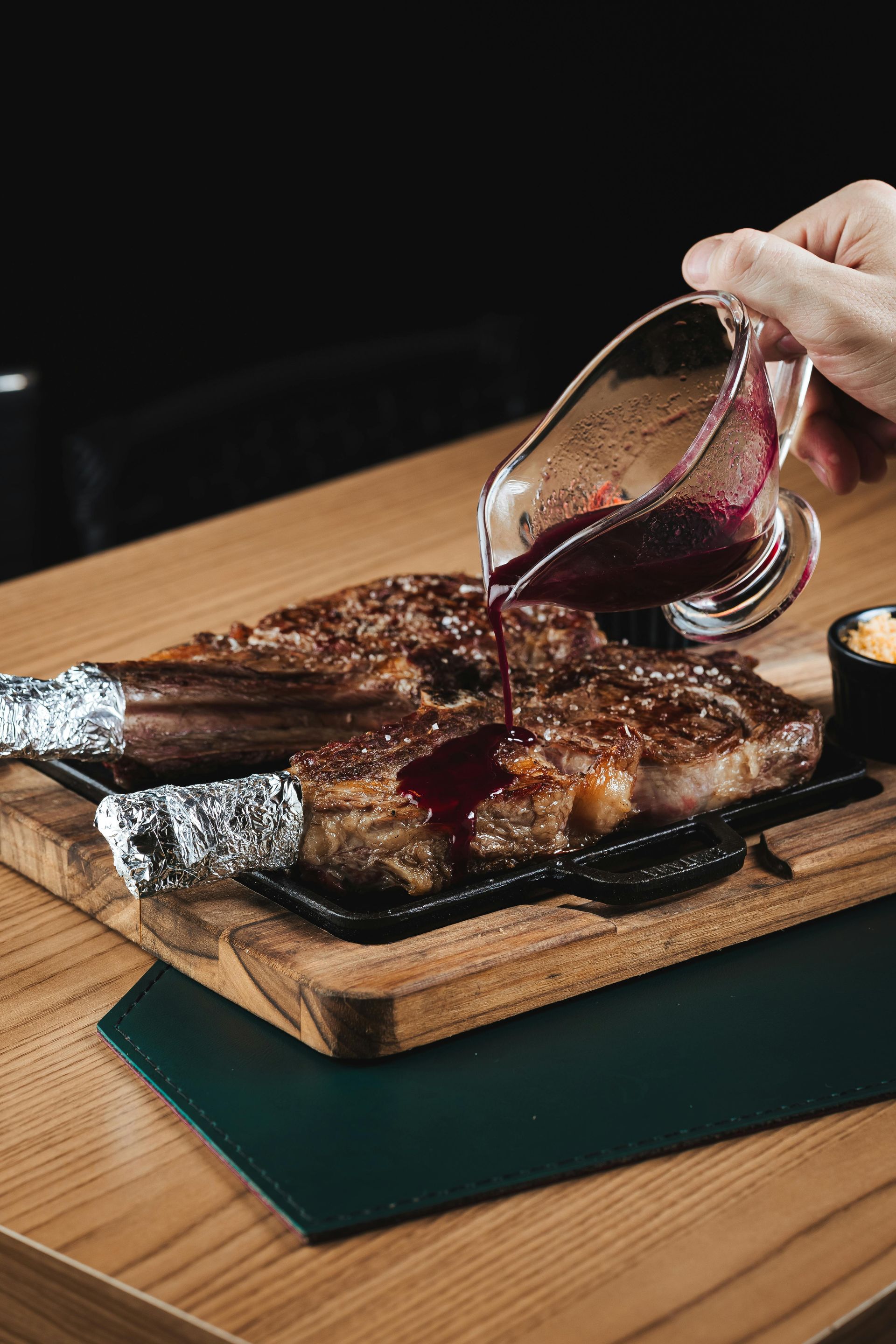 Steak with mashed potatoes, salad, and sauce on a white plate with silverware.
