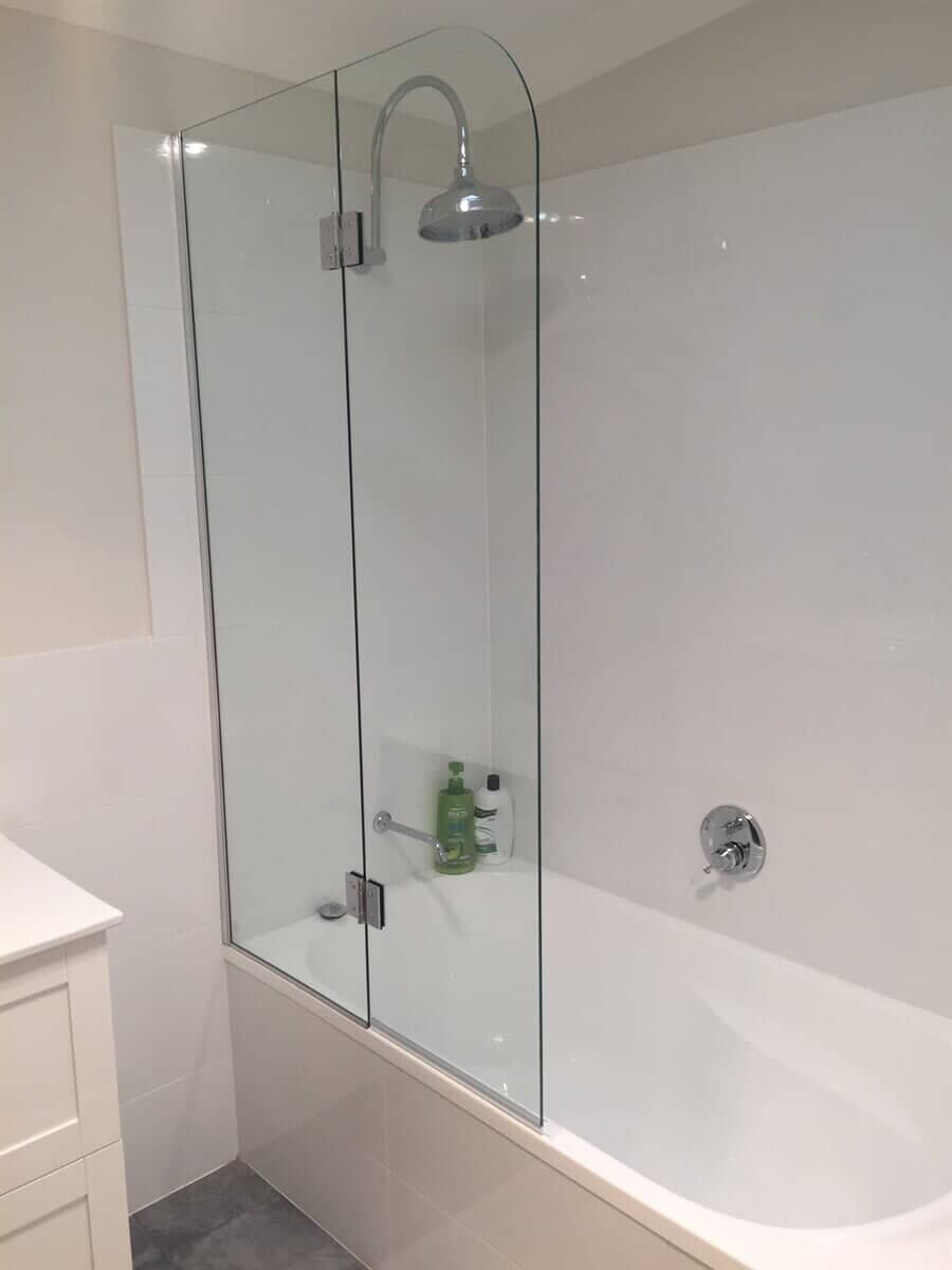 Modern bi-fold glass shower screen installed on a bath by Cessnock Glass