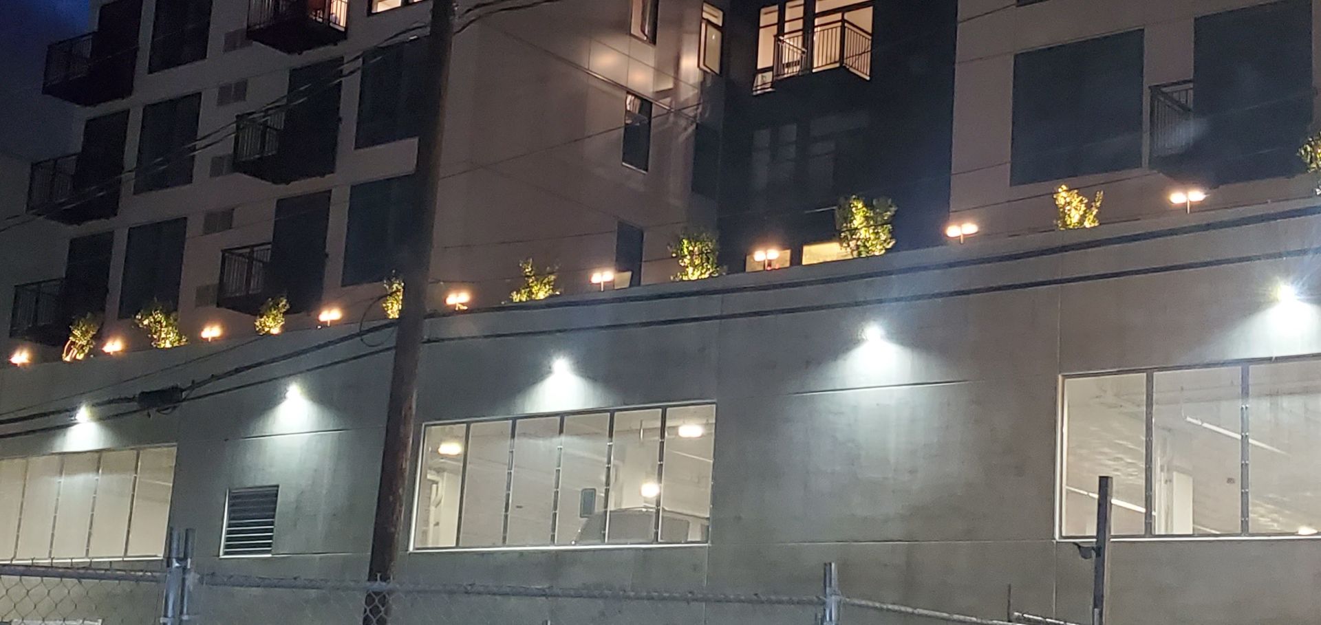 Night shot of a multi-story building with lit windows and decorative lights.