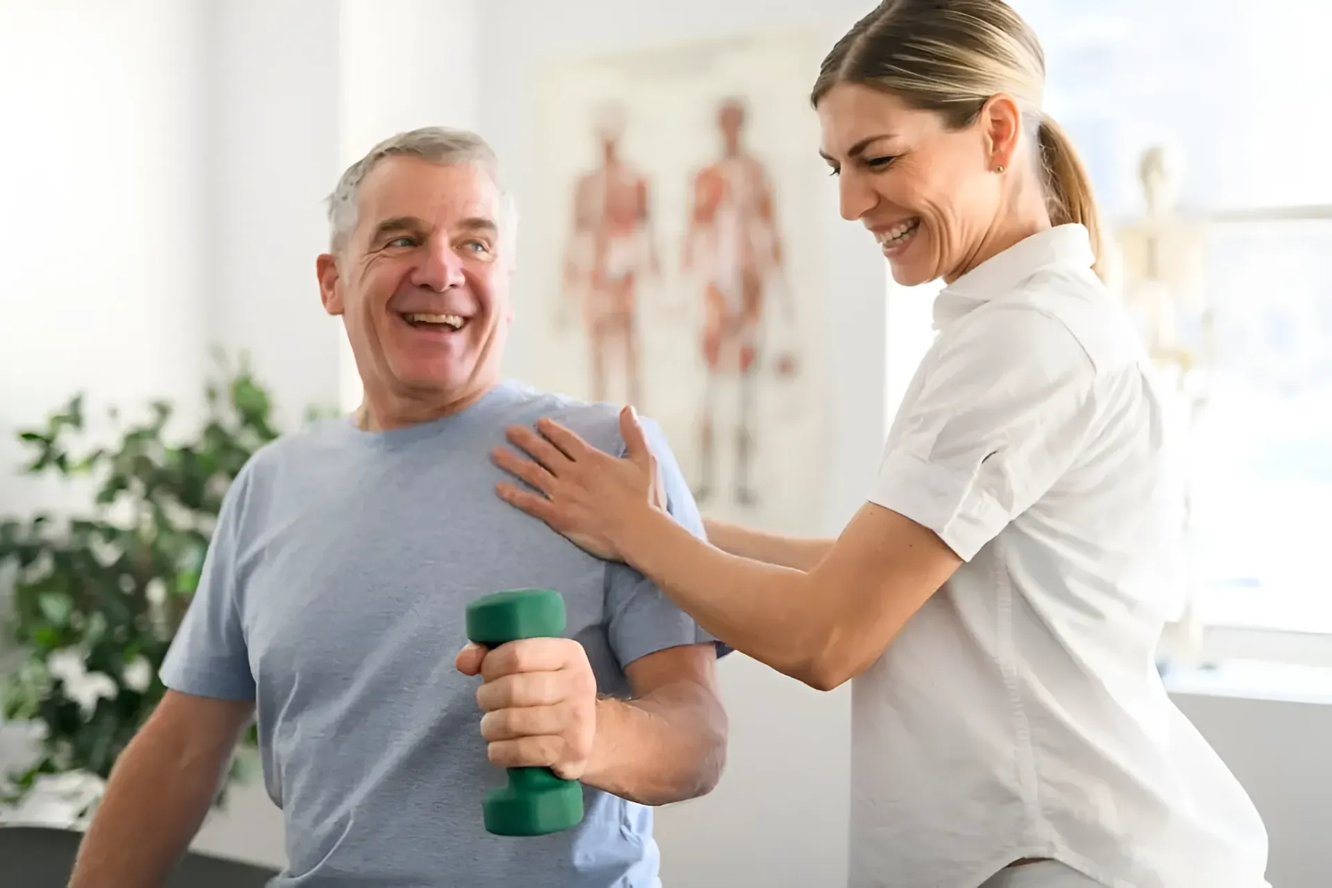 Man Holding a Dumbbell With a Physical Therapist Assisting — Barolin Physiotherapy Services in Bundaberg South, QLD