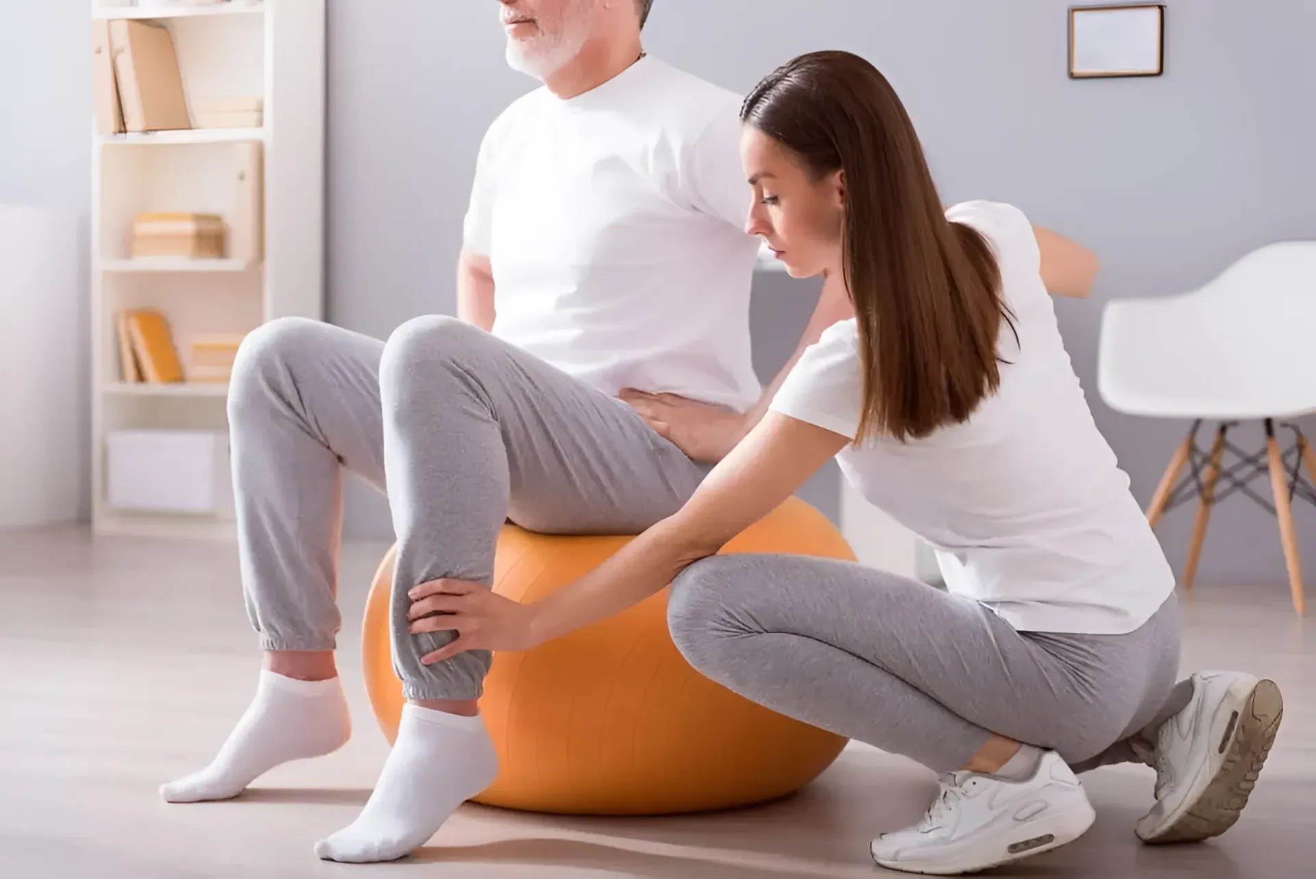 A Person is Assisting a Person Seated on an Exercise Ball — Barolin Physiotherapy Services in Bundaberg South, QLD