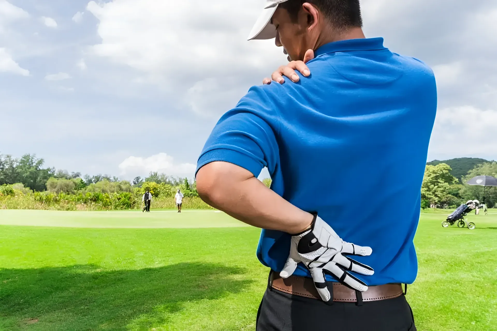 Golfer on a Course Holding His Shoulder, Appearing in Pain — Barolin Physiotherapy Services in Bundaberg South, QLD
