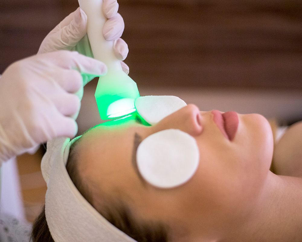 Woman getting a rejuvenation treatment on her face.