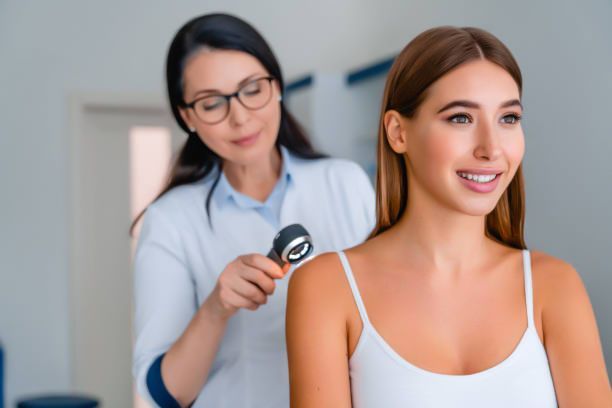 Dermatology exam at Greater Des Moines Dermatology in West Des Moines, IA, as a female doctor checks