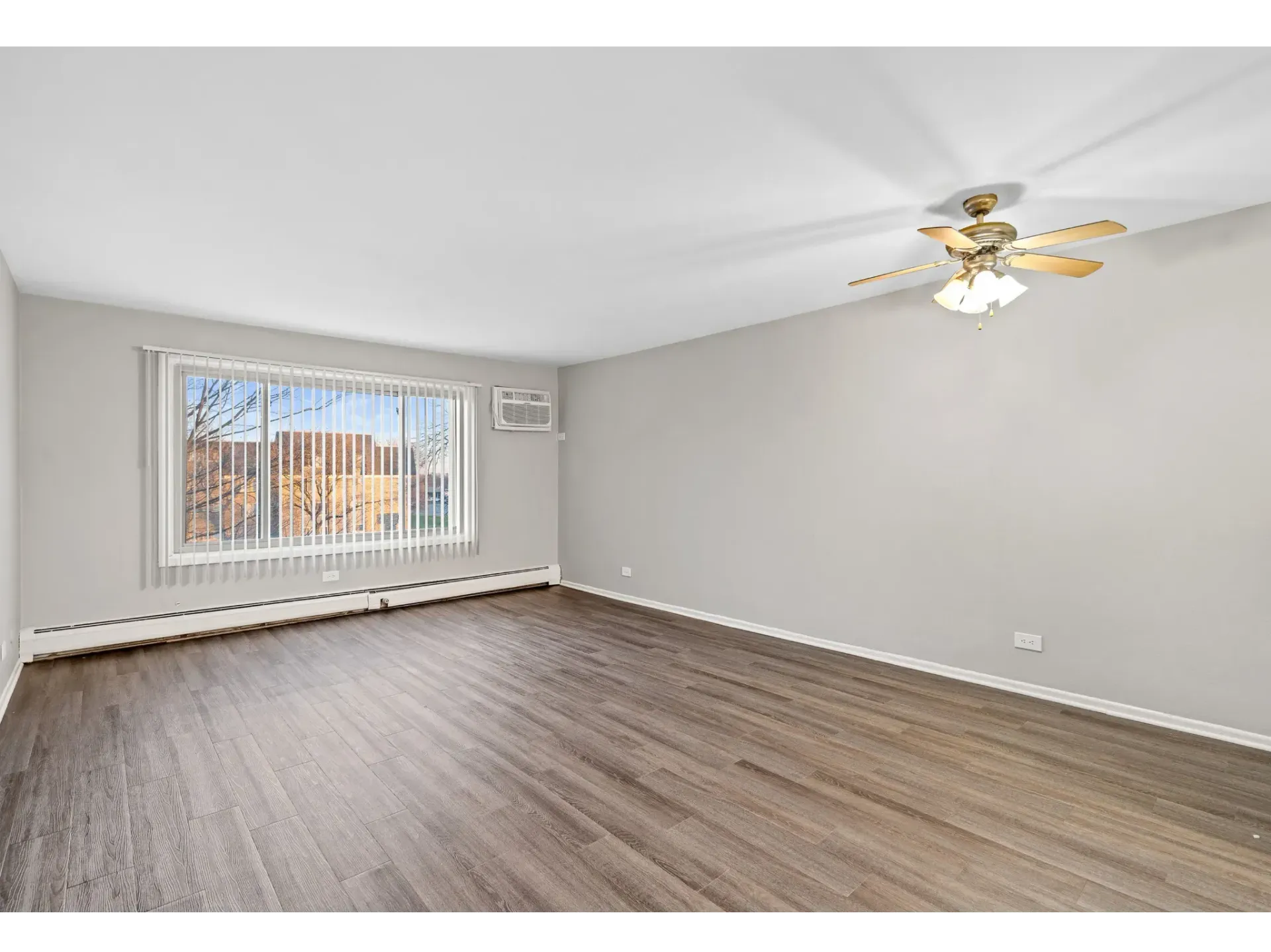 Spacious living room with large window and ceiling fan at Bartlett Lakes, offer pet-friendly apartments in Bartlett, IL.