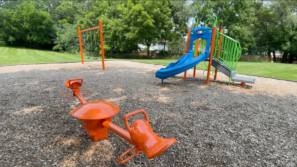 Colorful playground equipment in a park at Bartlett Lakes, offer apartments in Bartlett, IL.