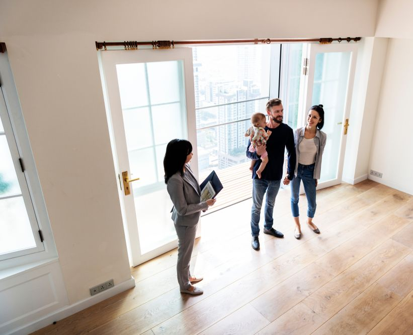 Real Estate Agent Showing a Family an Empty Room With a Balcony — Money Spider Conveyancing In Katherine, NT