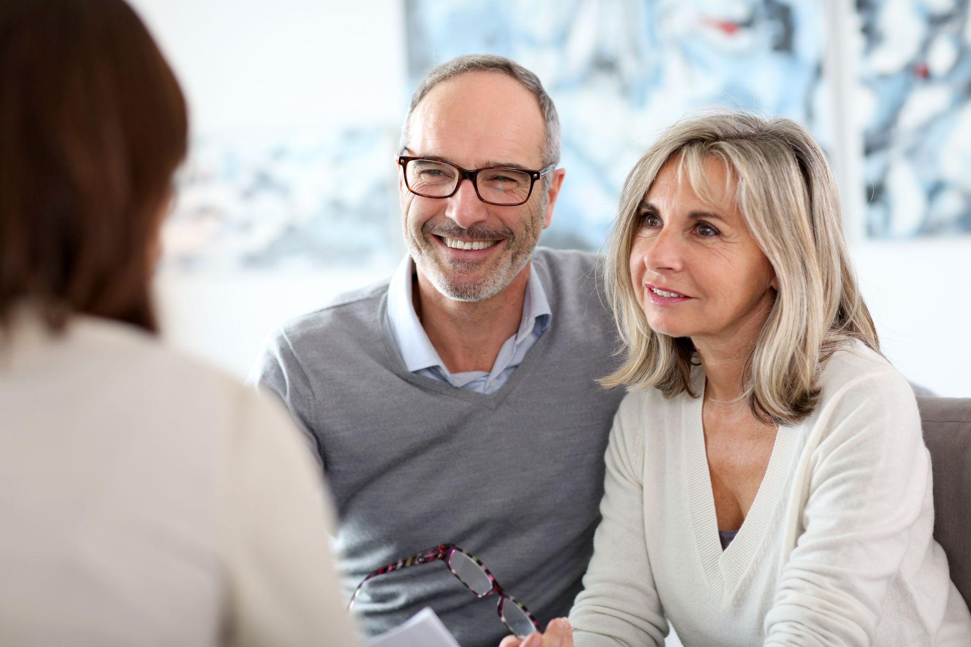 Mature Couple Smiling, Looking at a Person Seated in Front of Them — Money Spider Conveyancing In Katherine, NT