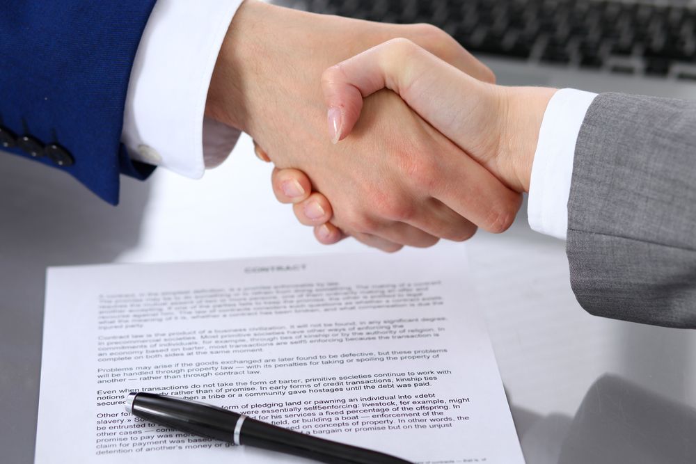 Two People Shaking Hands Over a Contract — Money Spider Conveyancing In Katherine, NT