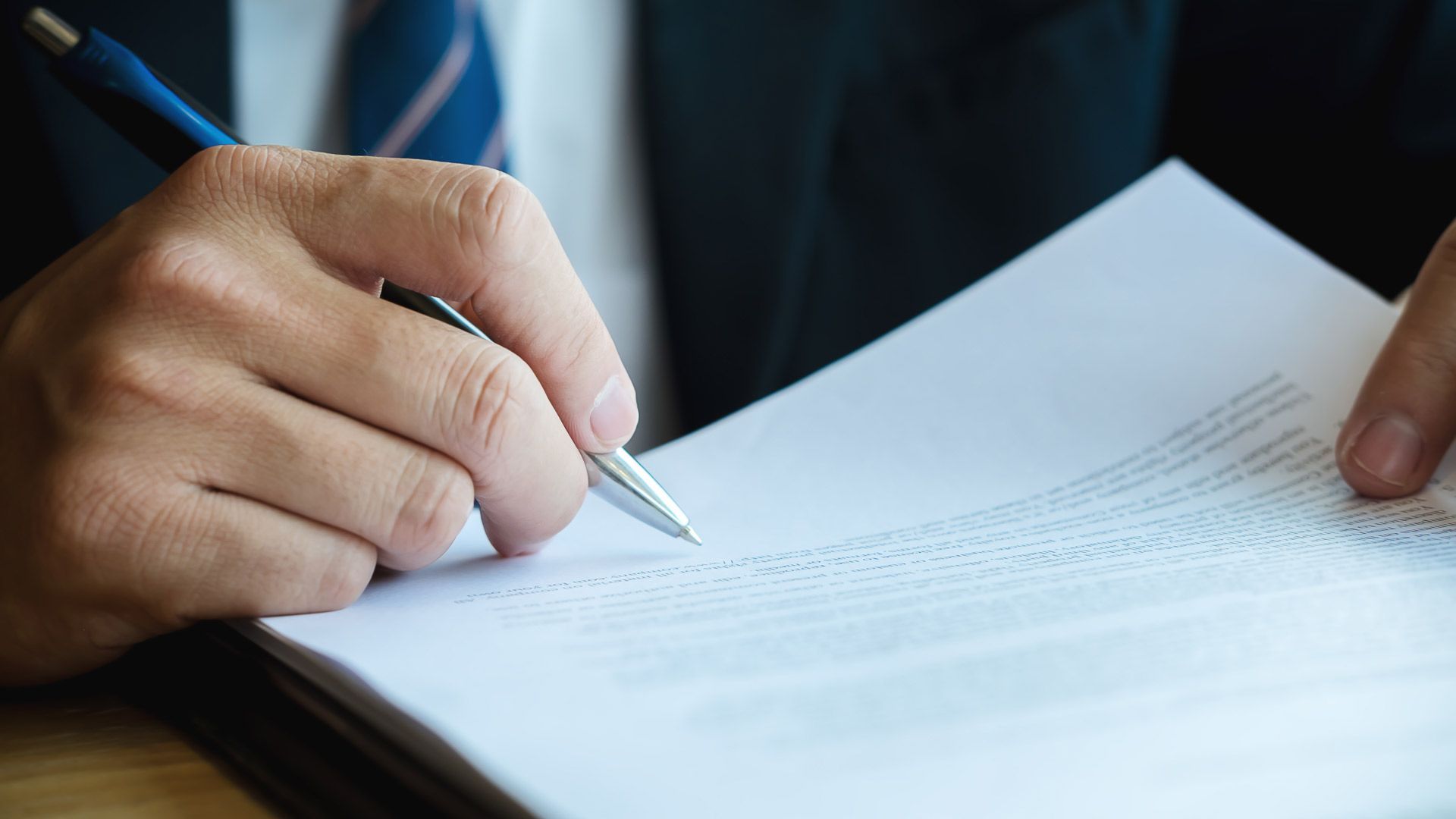 Person in Suit Writing on a Document With a Pen — Money Spider Conveyancing In Katherine, NT