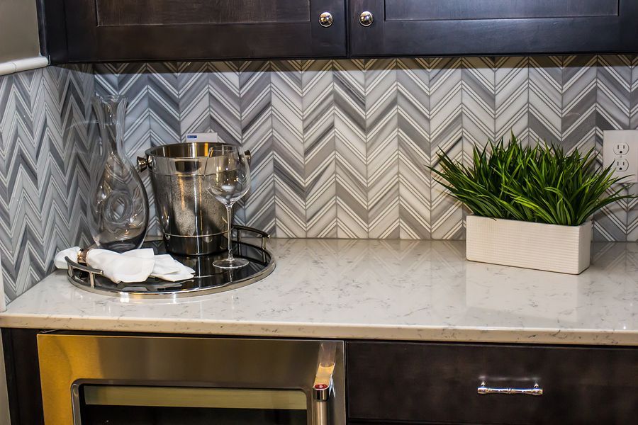 A kitchen counter with a bucket of wine and glasses on it