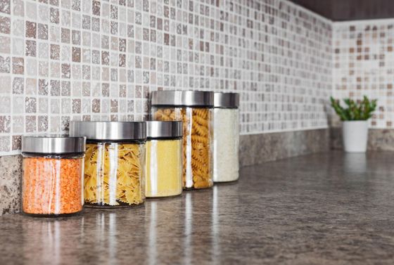 A row of glass jars filled with different types of food