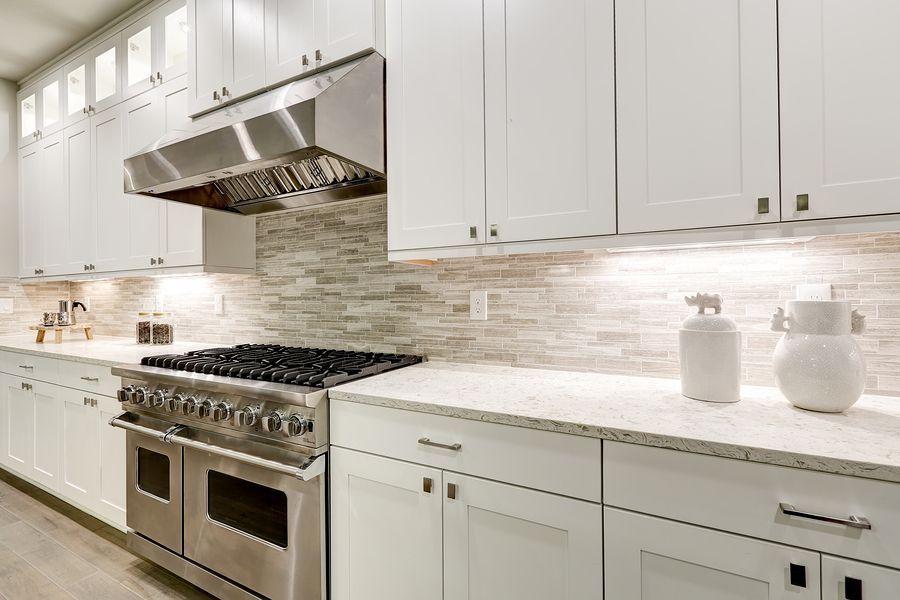 A kitchen with white cabinets and stainless steel appliances