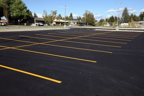 Image of a Asphalt Parking lot that has been recently paved. You can see a blacktop parking lot with yellow parking lot lines.