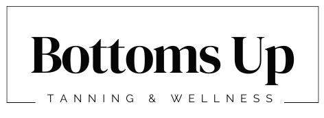 The logo for bottoms up tanning and wellness is black and white.