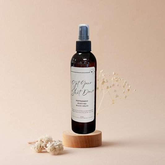 A bottle of spray sitting on top of a wooden block on a table.