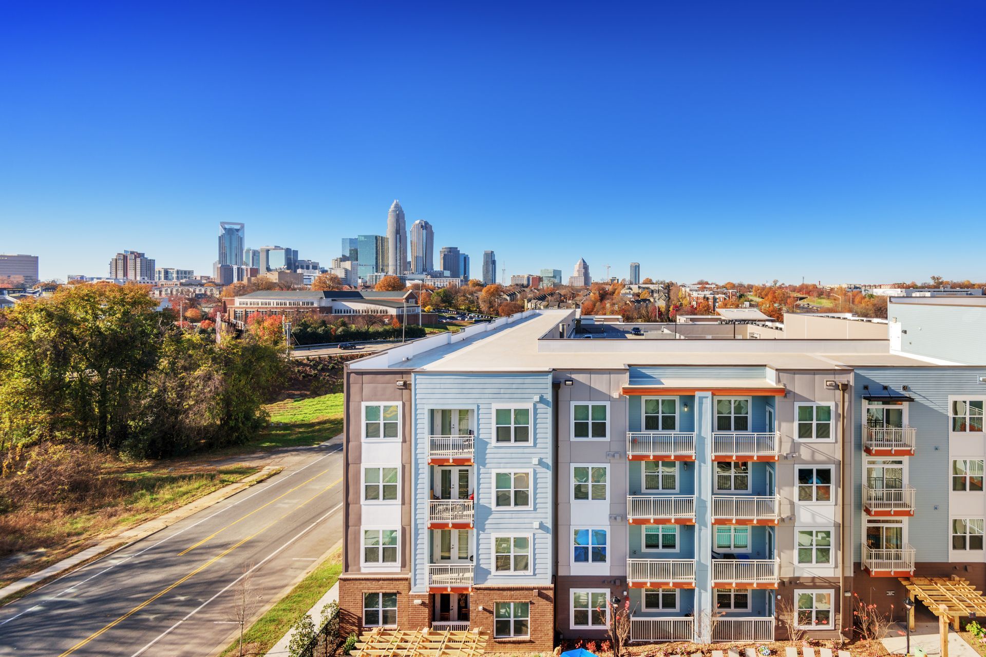 Apartment building with skyline view on a sunny day. Blue, gray, and brown building.