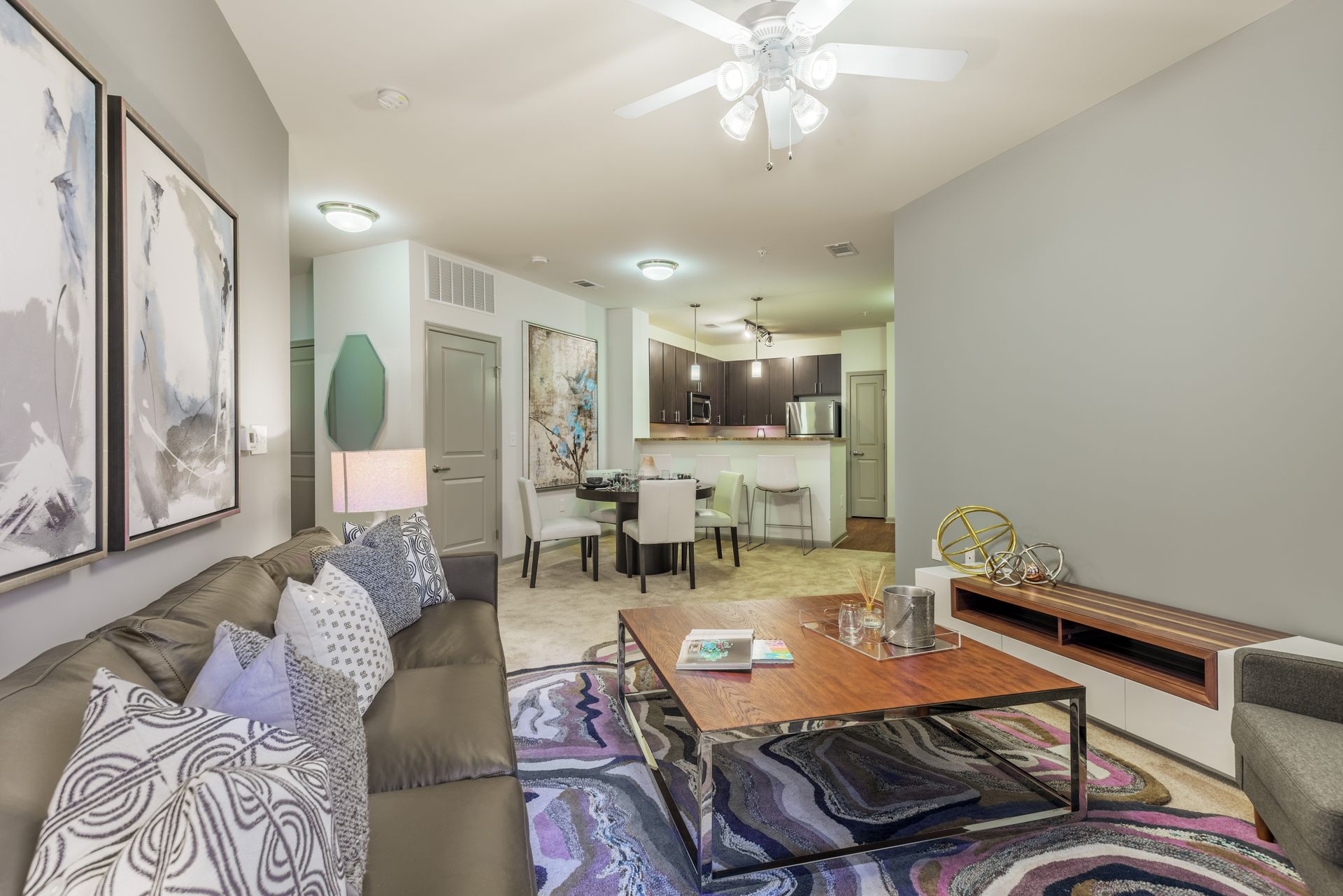 Living room with a gray couch, coffee table, and open kitchen area.