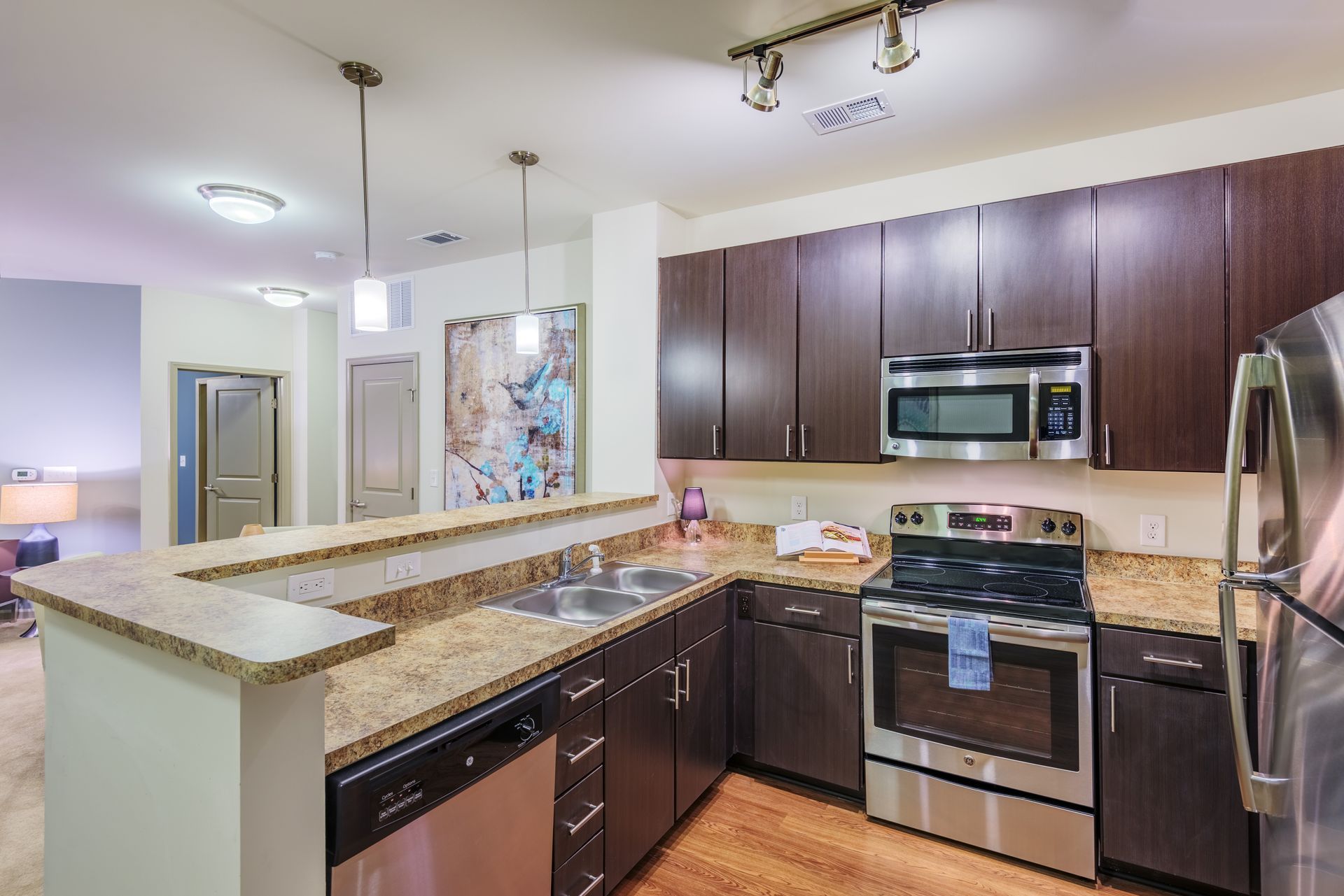 Modern kitchen with dark brown cabinets, stainless steel appliances, and granite countertops.