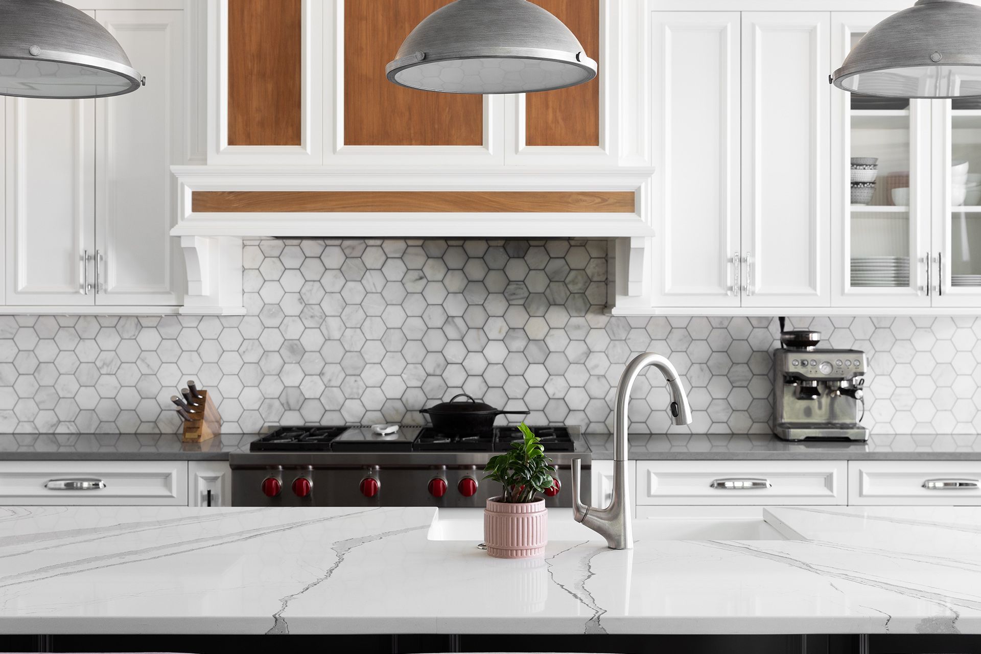 A modern kitchen features a marble island, white shaker cabinets