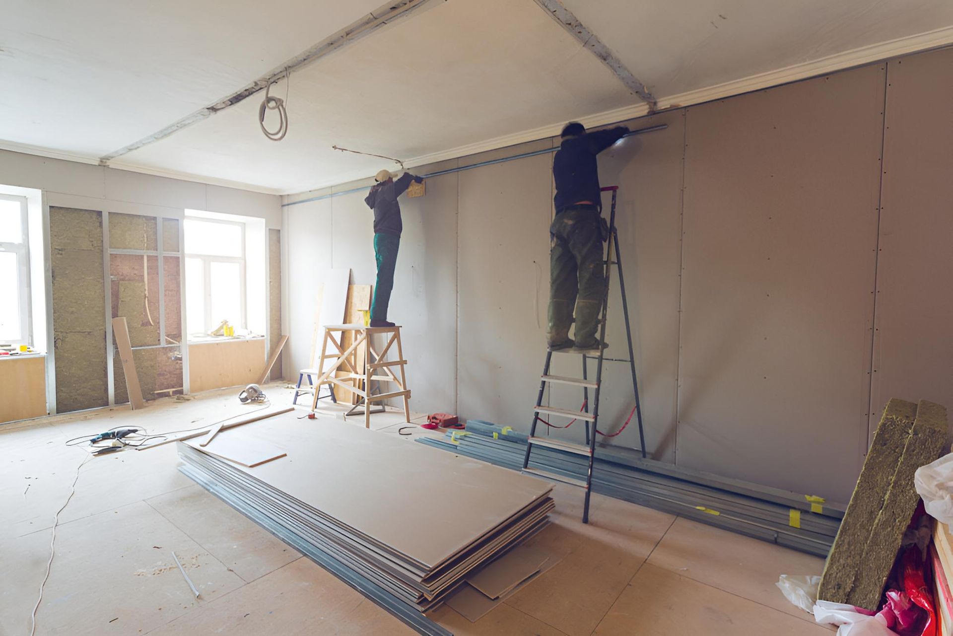 Two Men Are Working on a Wall in a Room — Central Coast Property Maintenance Services In Umina Beach, NSW
