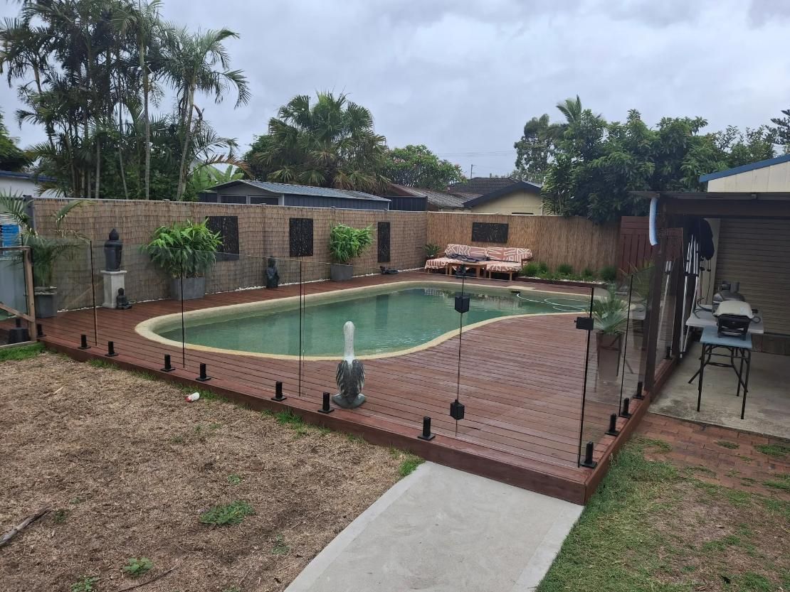 A Large Swimming Pool With Wooden Deck Flooring — Central Coast Property Maintenance Services In Umina Beach, NSW