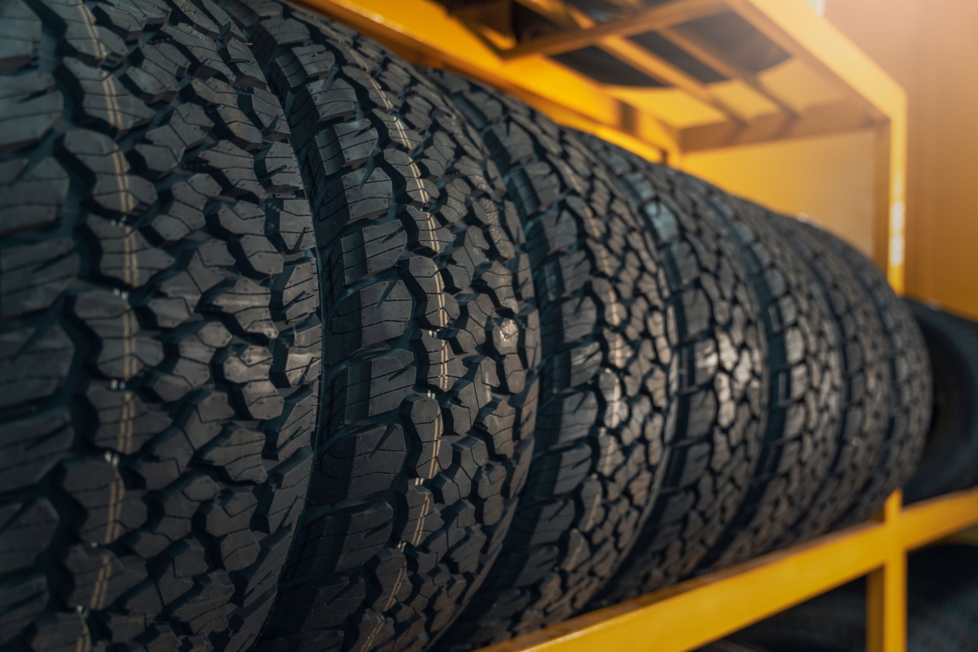 Car tyres neatly stacked in a warehouse with selective focus.