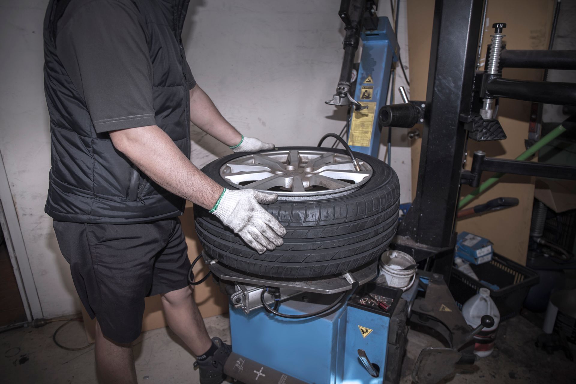Mechanic performing tyre service procedure in an auto repair shop