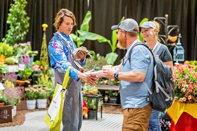 a man in a floral shirt is talking to a man in a blue shirt