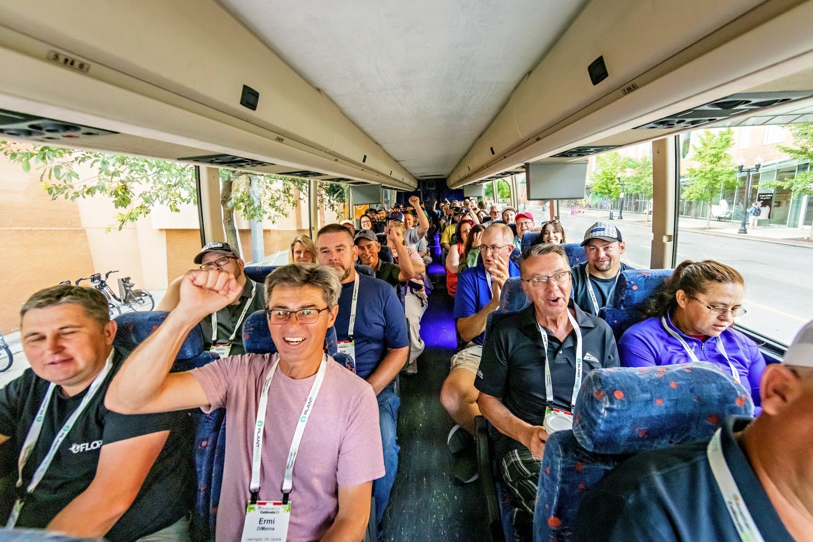 a group of people on a bus with one man wearing a lanyard 