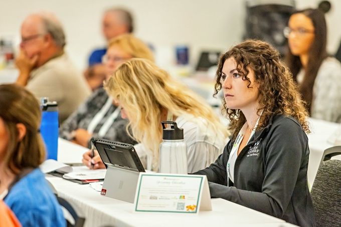 a woman sits at a table with a sign that says ' amanda ' on it