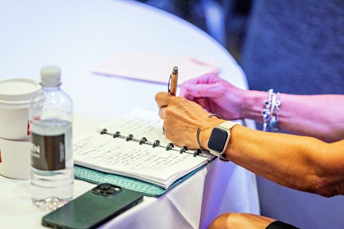 a woman wearing an apple watch is writing in a notebook