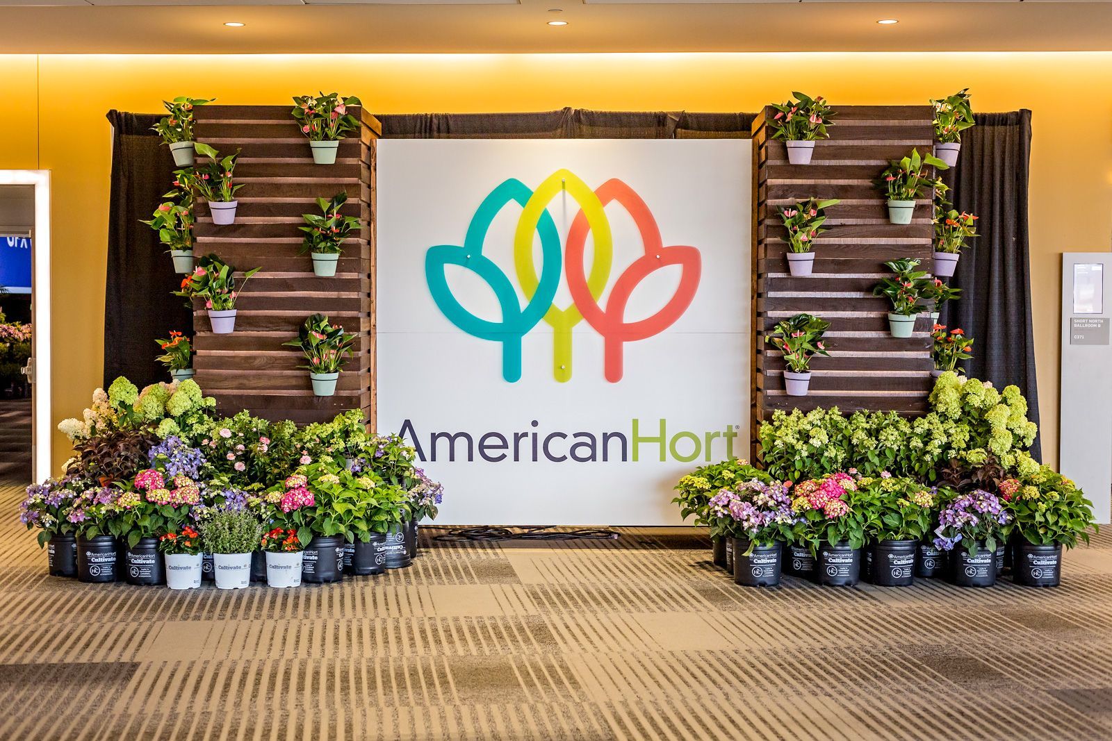 a display of potted plants and a sign that says AmericanHort
