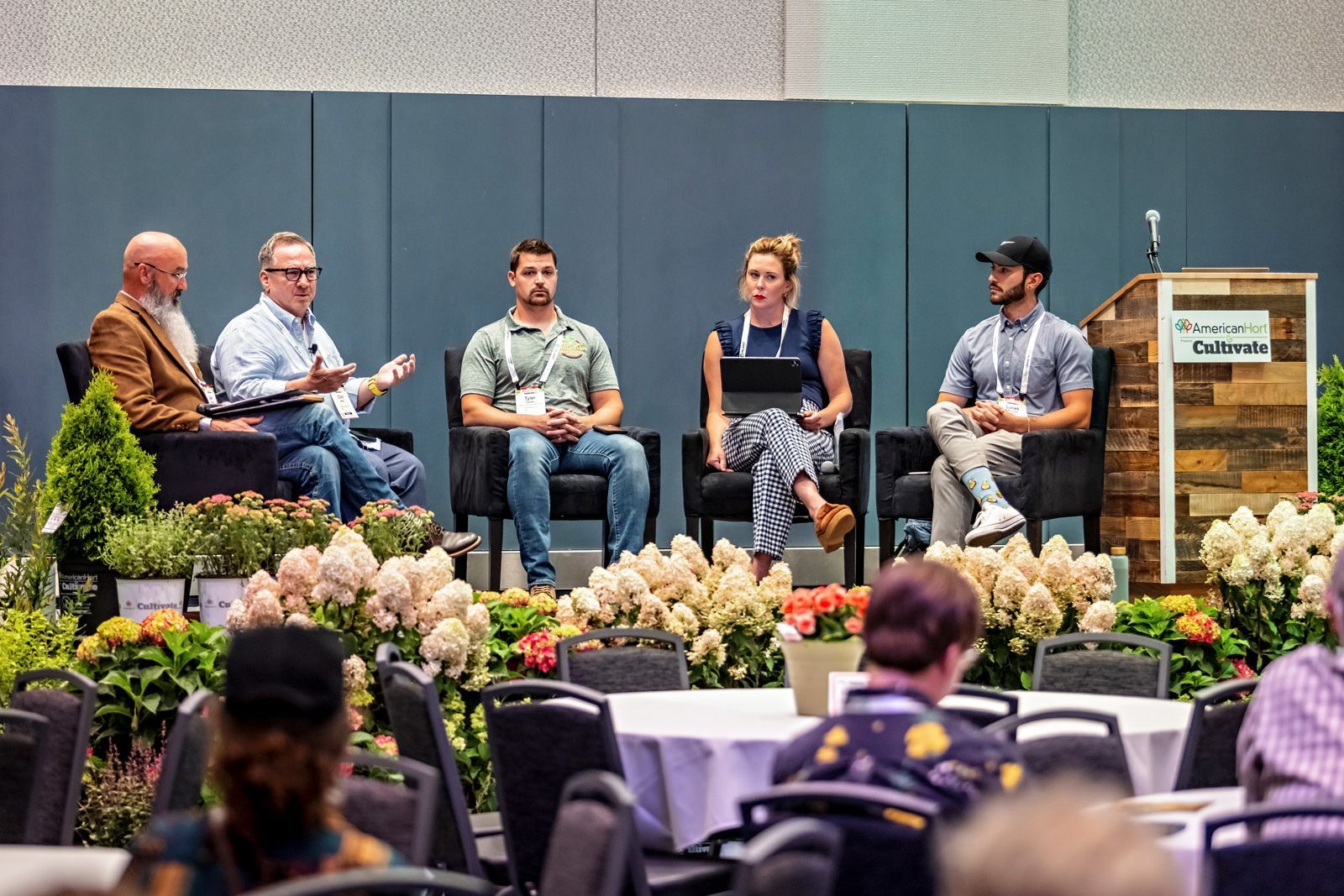 a group of people sitting in front of a podium that says cultivate