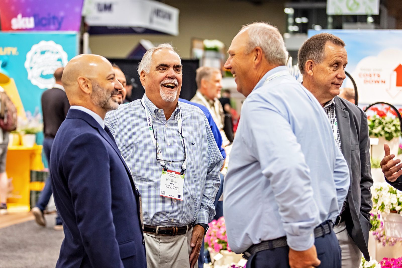 Group of individuals laughing on the tradeshow floor at Cultivate
