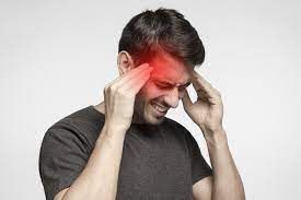 A man is holding his head in pain because of a headache.