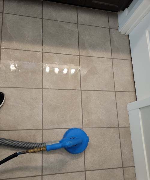 A blue vacuum cleaner is sitting on a tiled floor