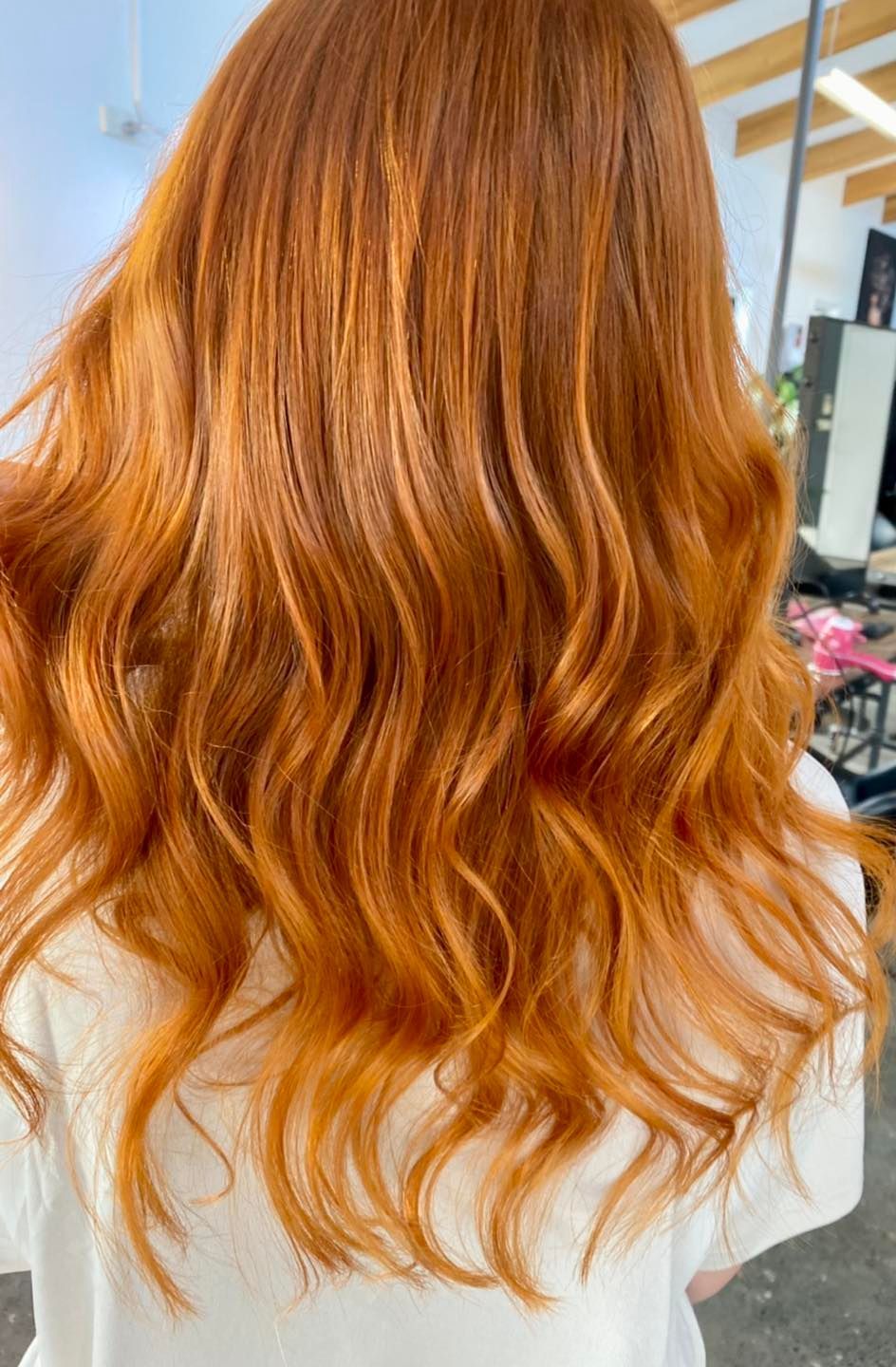 A woman with white hair is wearing a white sweater.