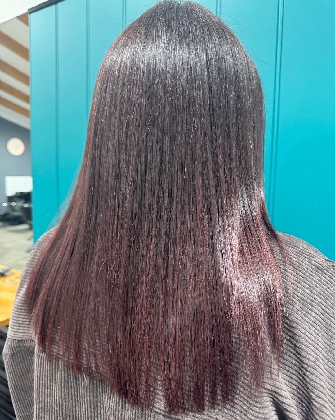 Woman with dark, smooth hair, transitioning to a red-violet hue.