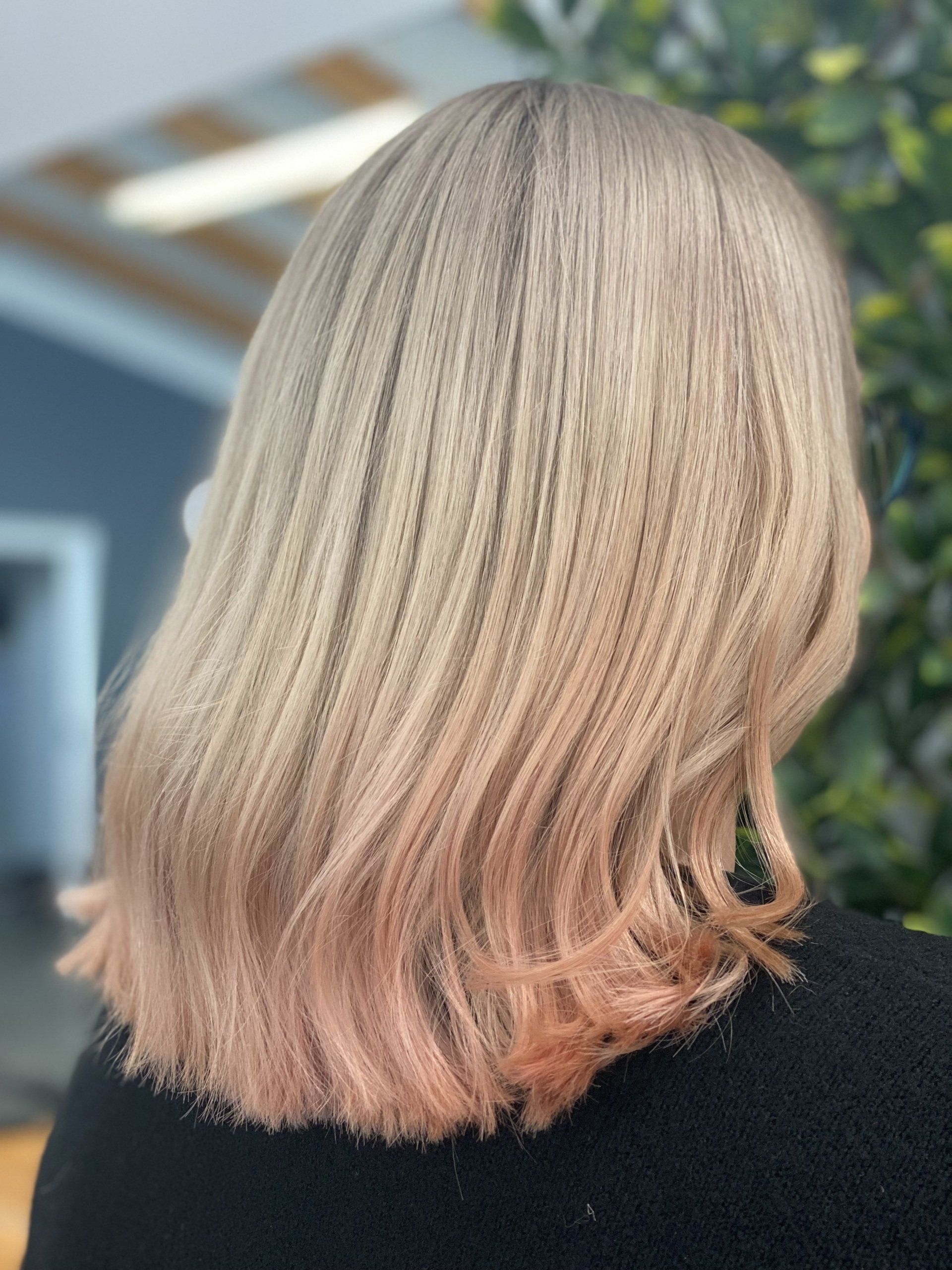 Woman with blonde, crimped hair, fading to a pinkish hue at the ends.