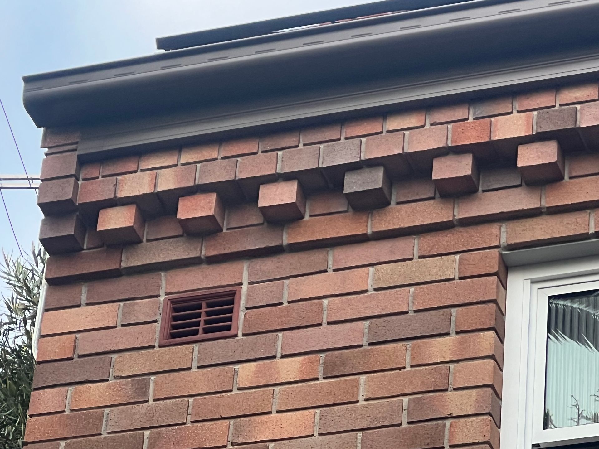 A Close Up Of A Brick Building At The Roof Junction — Heritage Bricklaying & Remedial Services In Jilliby, NSW