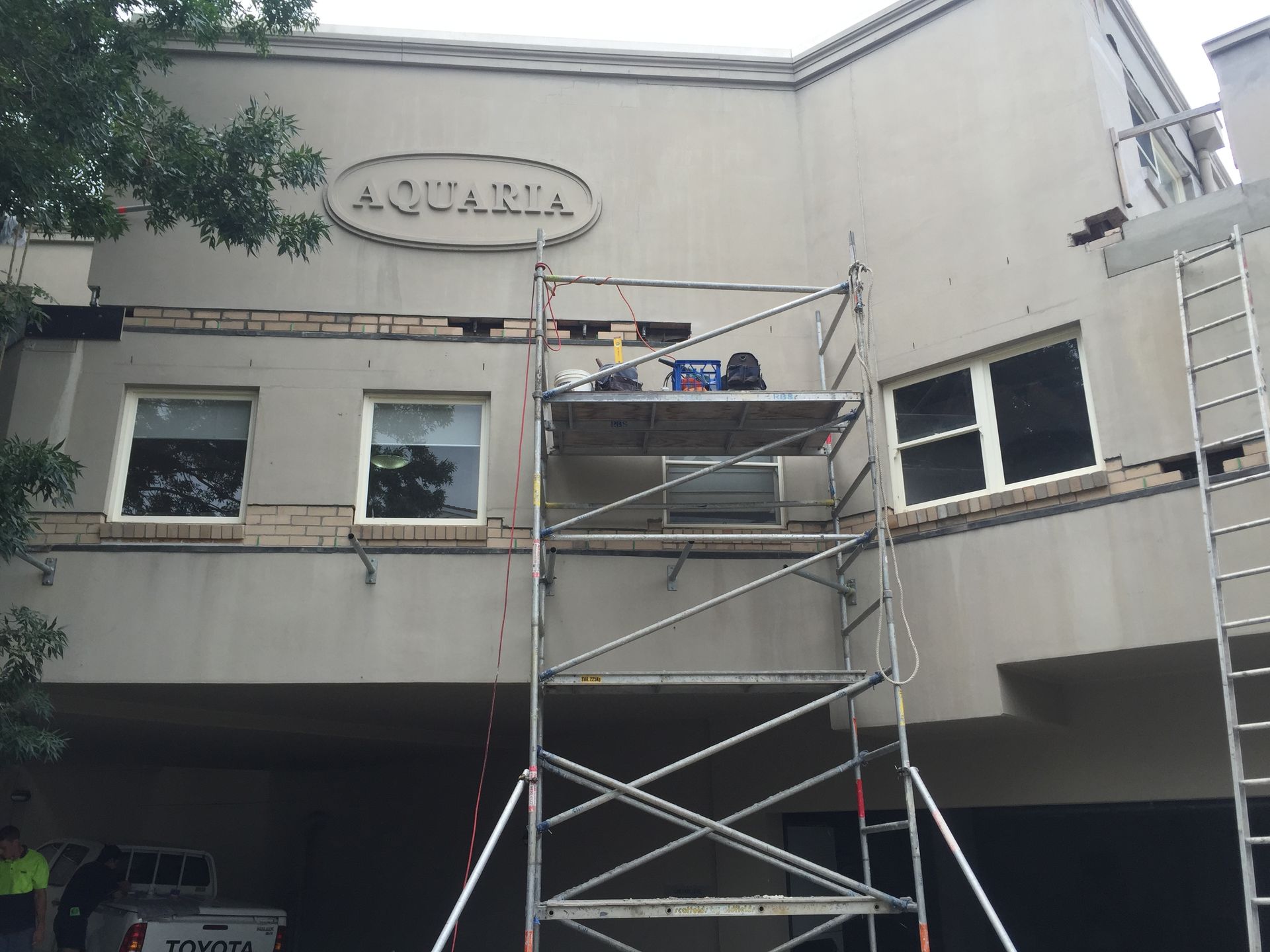A Brick Building With A Scaffolding In Front Of It — Heritage Bricklaying & Remedial Services In Jilliby, NSW