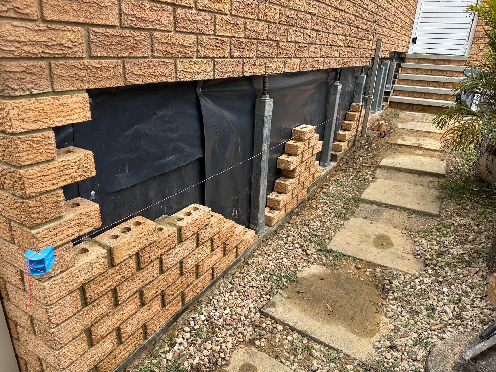 A Brick Building With A Scaffolding In Front Of It — Heritage Bricklaying & Remedial Services In Jilliby, NSW