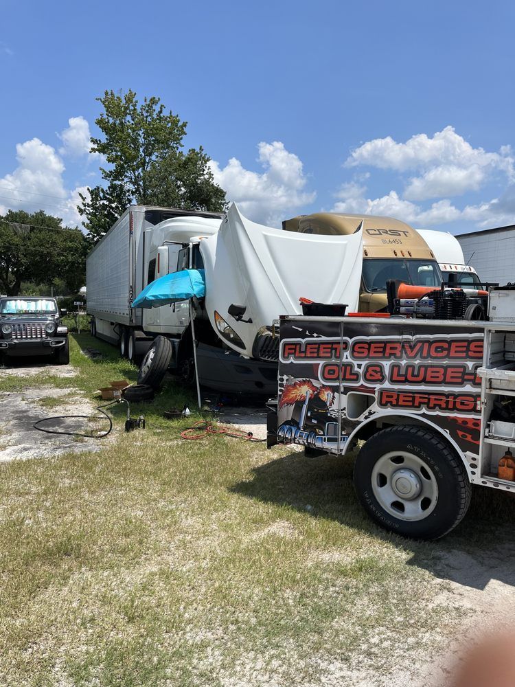 A truck is being towed by a fleet service oil & lube tow truck.