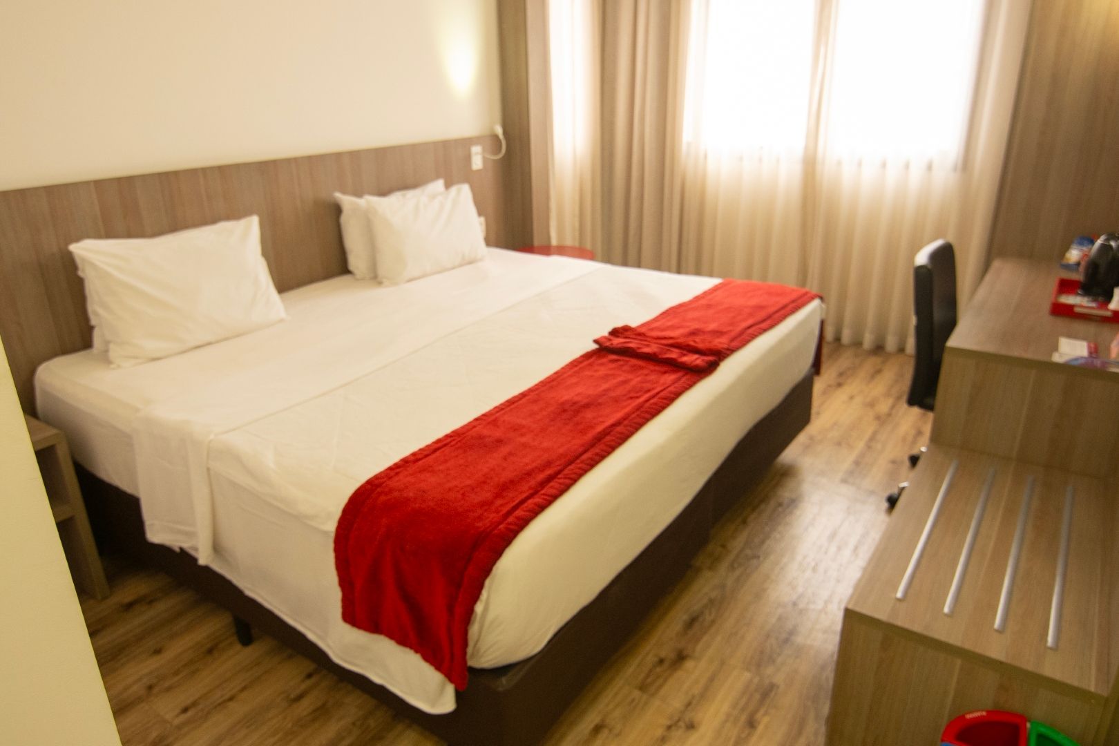 Um quarto de hotel com uma cama grande e uma escrivaninha