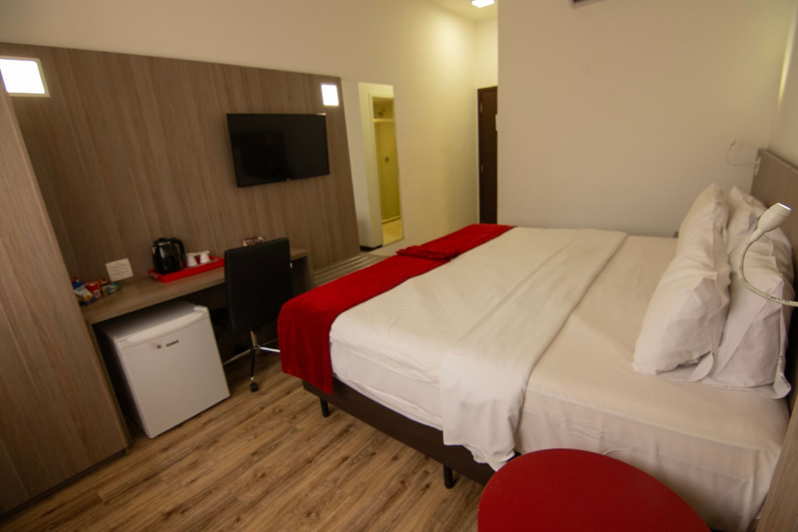 Um quarto de hotel com uma cama king size e uma TV de tela plana.