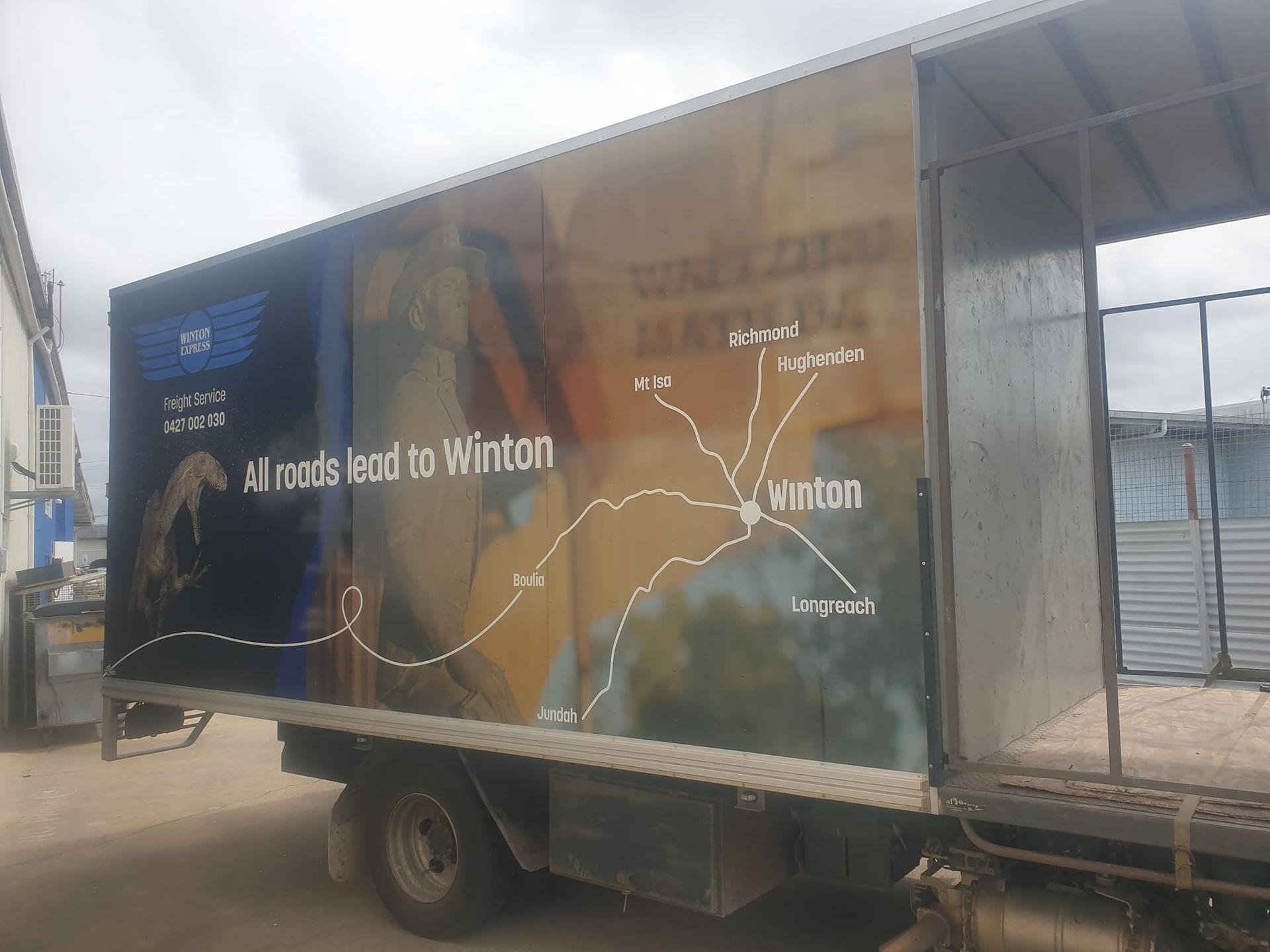 A truck with a map on the side is parked in a parking lot.